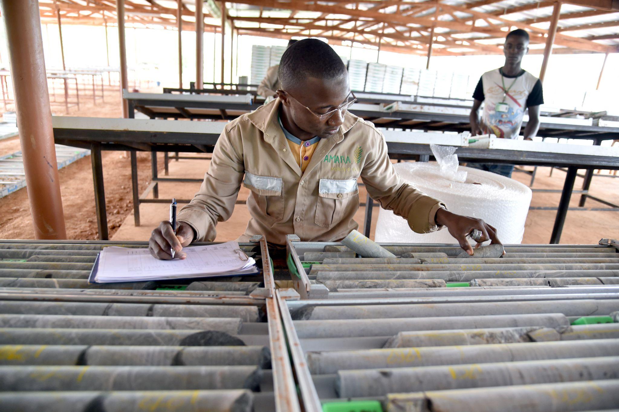 Ghanaian geologists conducting fieldwork and examining samples